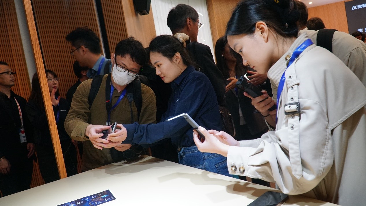 發(fā)布會(huì)上，與會(huì)嘉賓試用訊飛雙屏翻譯機(jī)2.0。人民網(wǎng) 蔣曉辰攝