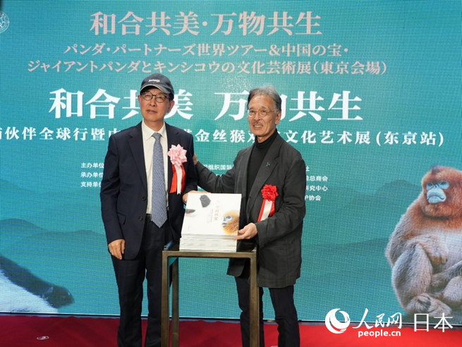 薛康（左）與土居利光（右）為《中國雙寶：享譽世界的大熊貓和金絲猴》攝影畫冊發(fā)布揭幕。人民網(wǎng) 許可攝