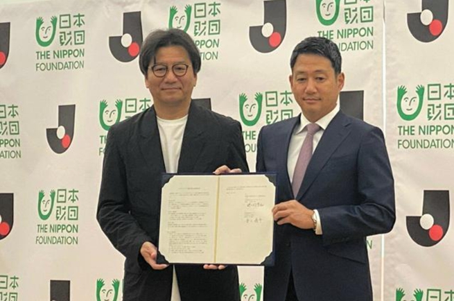 [配圖說明：出席合作協(xié)定簽訂儀式的日本職業(yè)足球聯(lián)賽主席野野村芳和（左）與日本財(cái)團(tuán)的笹川順平專務(wù)理事]