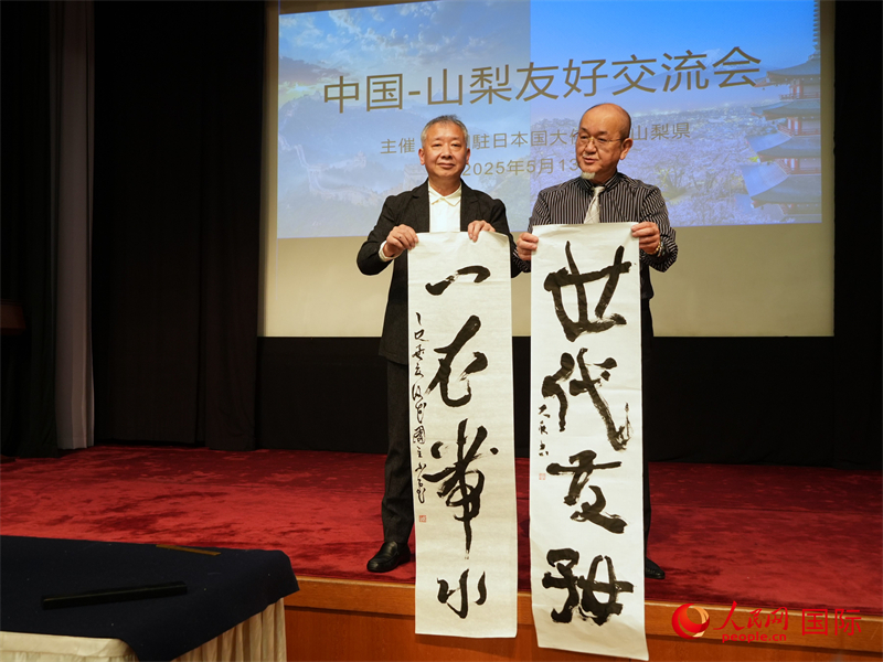 兩國(guó)書法家共同書寫“一衣帶水、世代友好”。人民網(wǎng) 許可攝